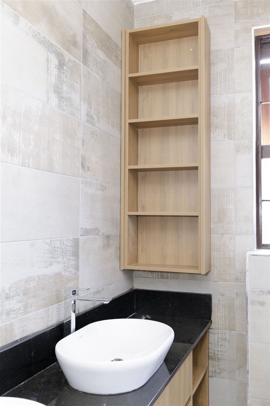 Corner bathroom vanity with timber shelving and black granite counter
