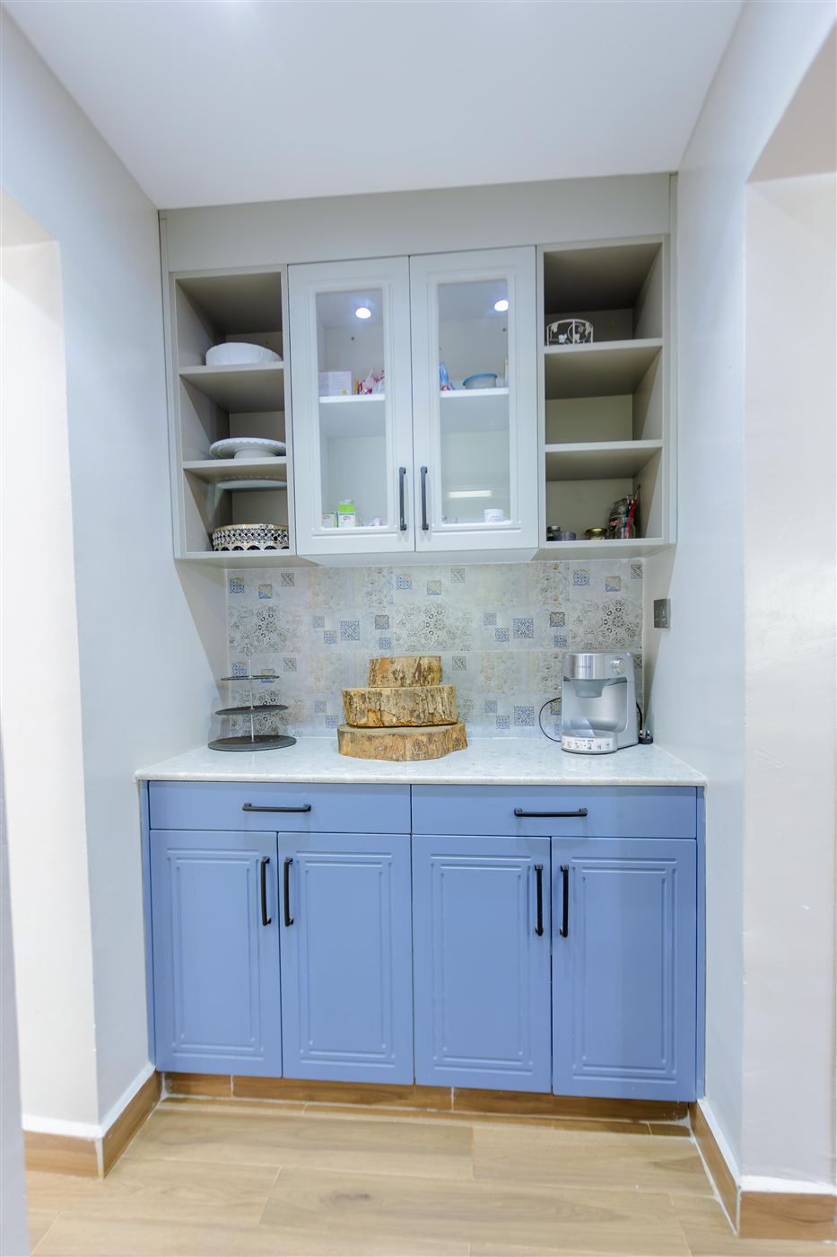 Butler's pantry with glass-front display cabinet and blue lower cabinetry